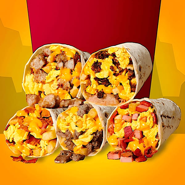 Five breakfast burritos overflowing with eggs, cheese, sausage, bacon, and potatoes.